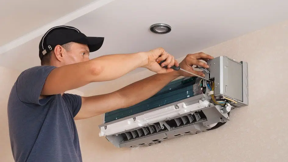 Man repairing an indoor mini-split air conditioner.