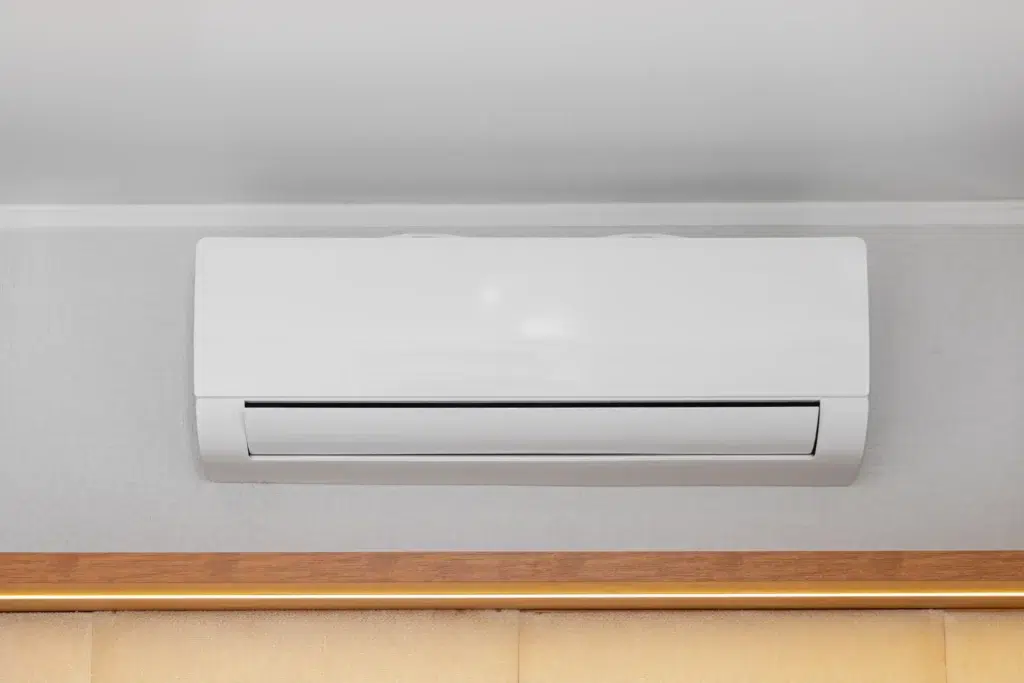 White wall-mounted air conditioner on a light-colored wall with a sleek, modern design