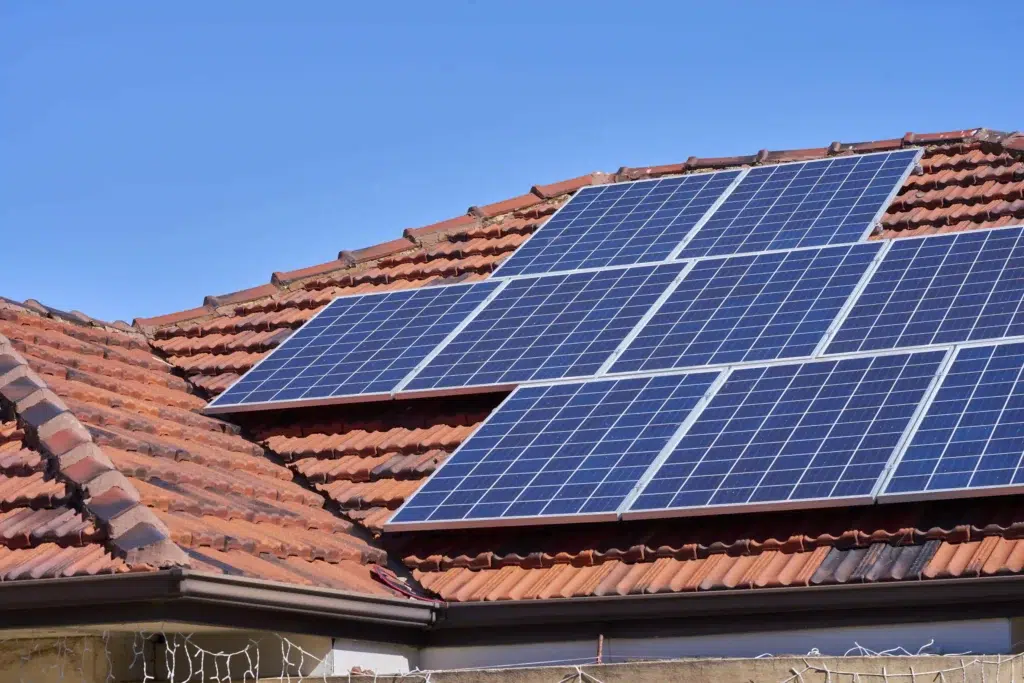 Solar panels installed on a red tile roof.