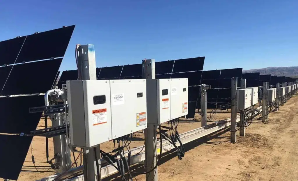 Commercial solar panel array with inverters in desert.