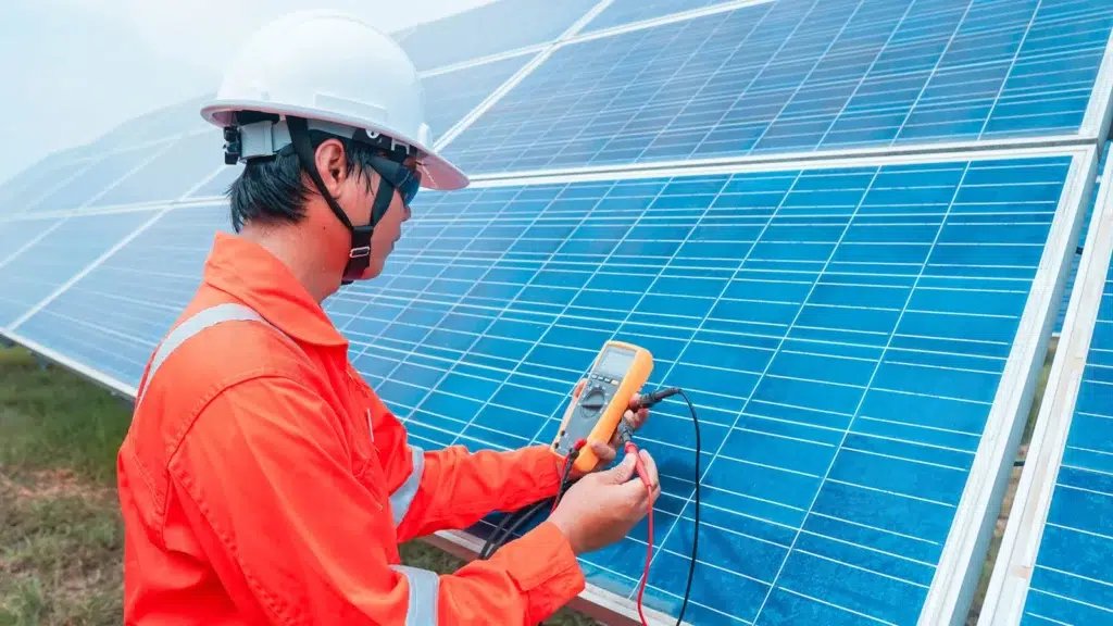 Man tests solar panels with a multimeter.