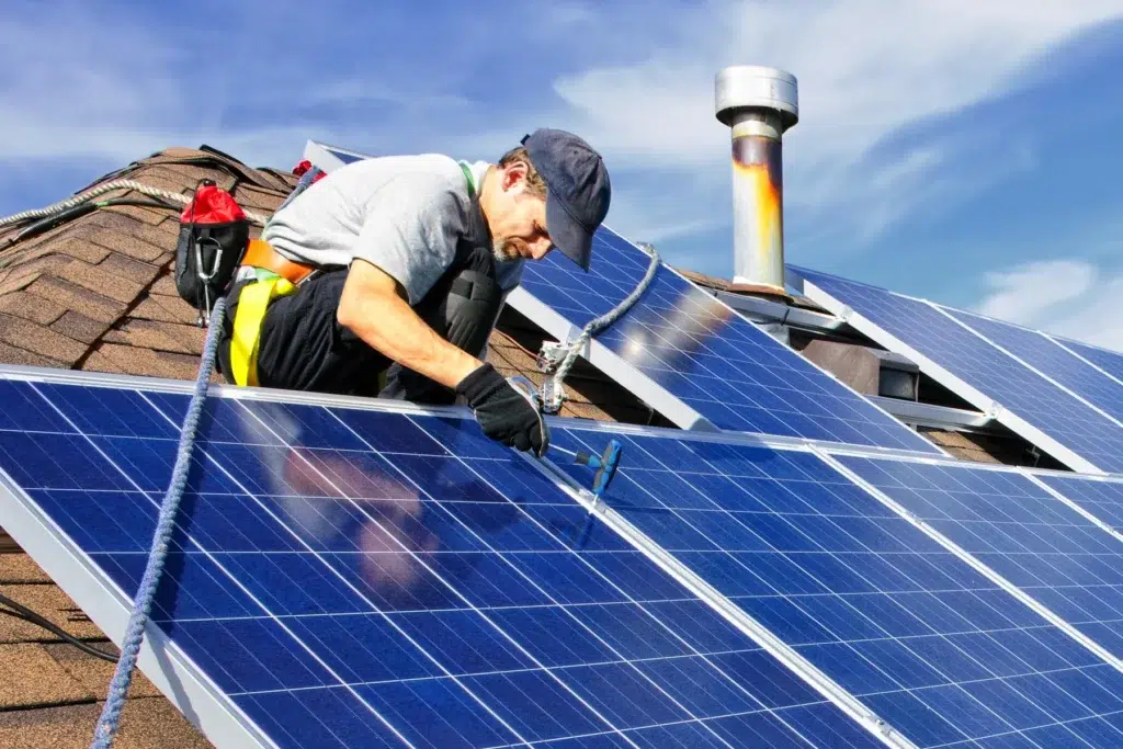 Man working on rooftop solar panel installation.