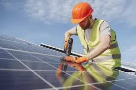 Man drills into solar panel on roof.